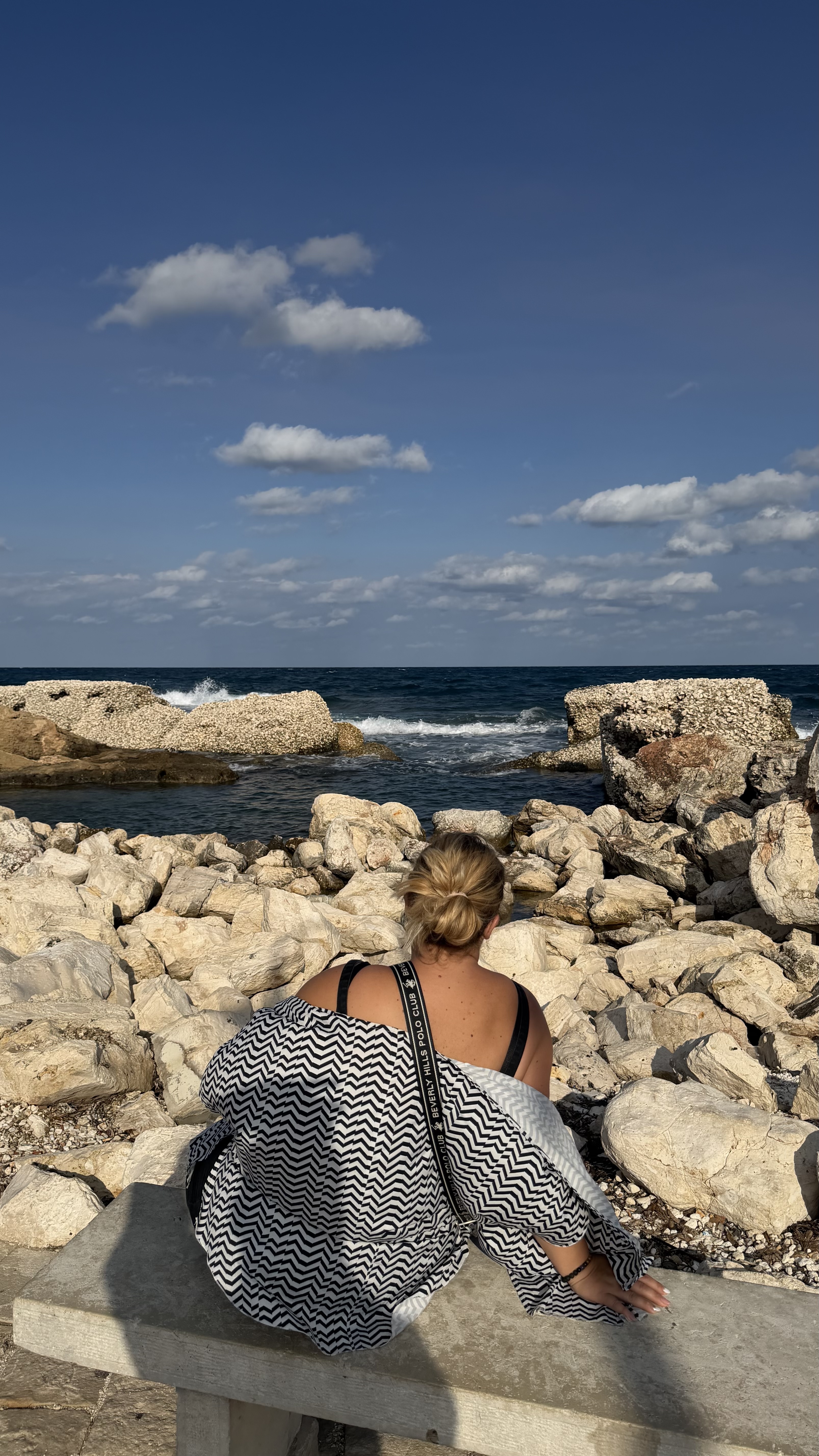 Fotó: Alexandra a tengerparton ül, a horizontot nézi.